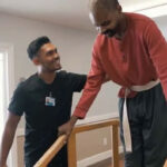 Male nurse helps a male patient in walking rehab